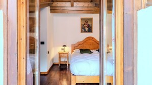 Ein Zimmer mit Holzrahmen, ausgestattet mit einem Bett, einem Nachttisch, einer Lampe und einem Bild an der Wand.