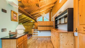 Ein Holzinnenraum mit Treppe, Holzschränken und einer Chandelüster.