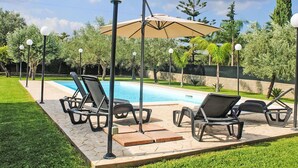 A poolside area with lounge chairs and a pergola. - Wonderful private villa for 6 guests with A/C, WIFI, private pool, TV and patio (Syracuse)