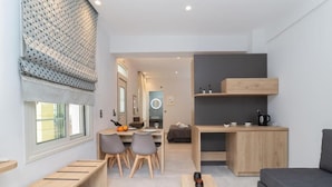 Een moderne, compacte woonruimte met een eethoek, kitchenette en zithoek.