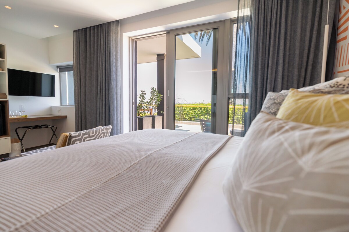 Suite Deluxe, patio, vistas al mar | Caja fuerte, escritorio, espacio para trabajar con un portátil
