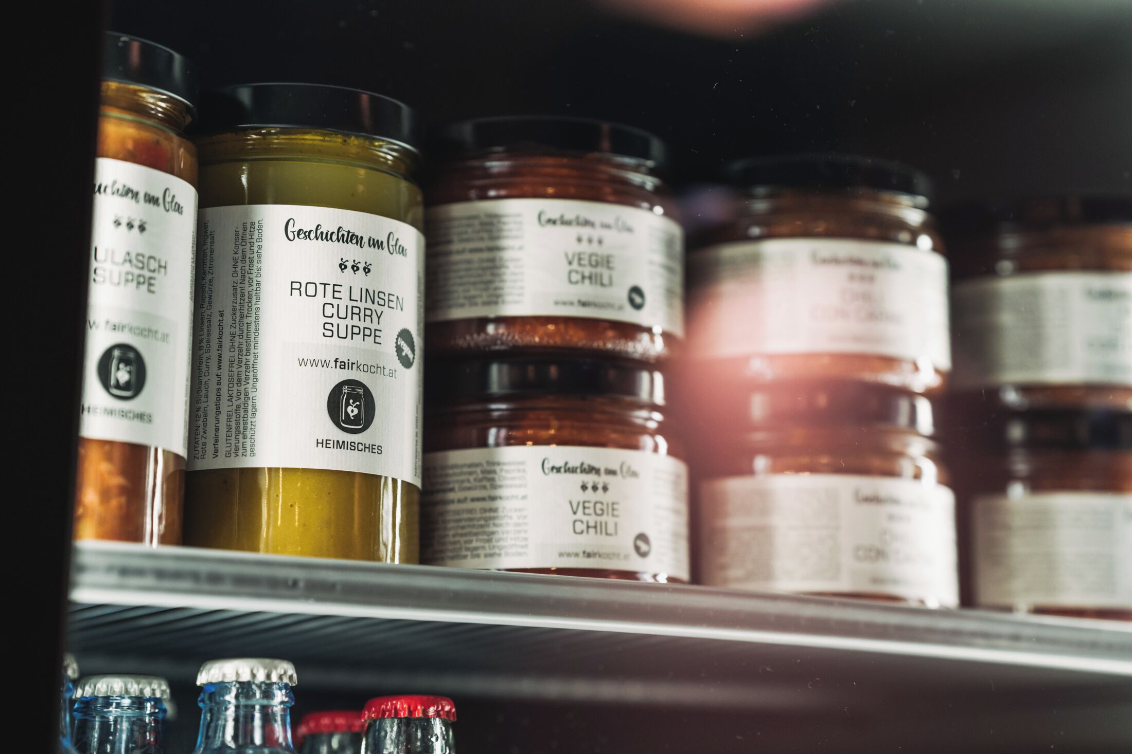 A shelf with jars of condiments including curry and chili.