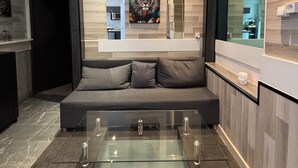 A modern living room with a glass coffee table, a grey sofa, and a large painting on the wall. - Le Darcy / DIJON train station and city center (Dijon)