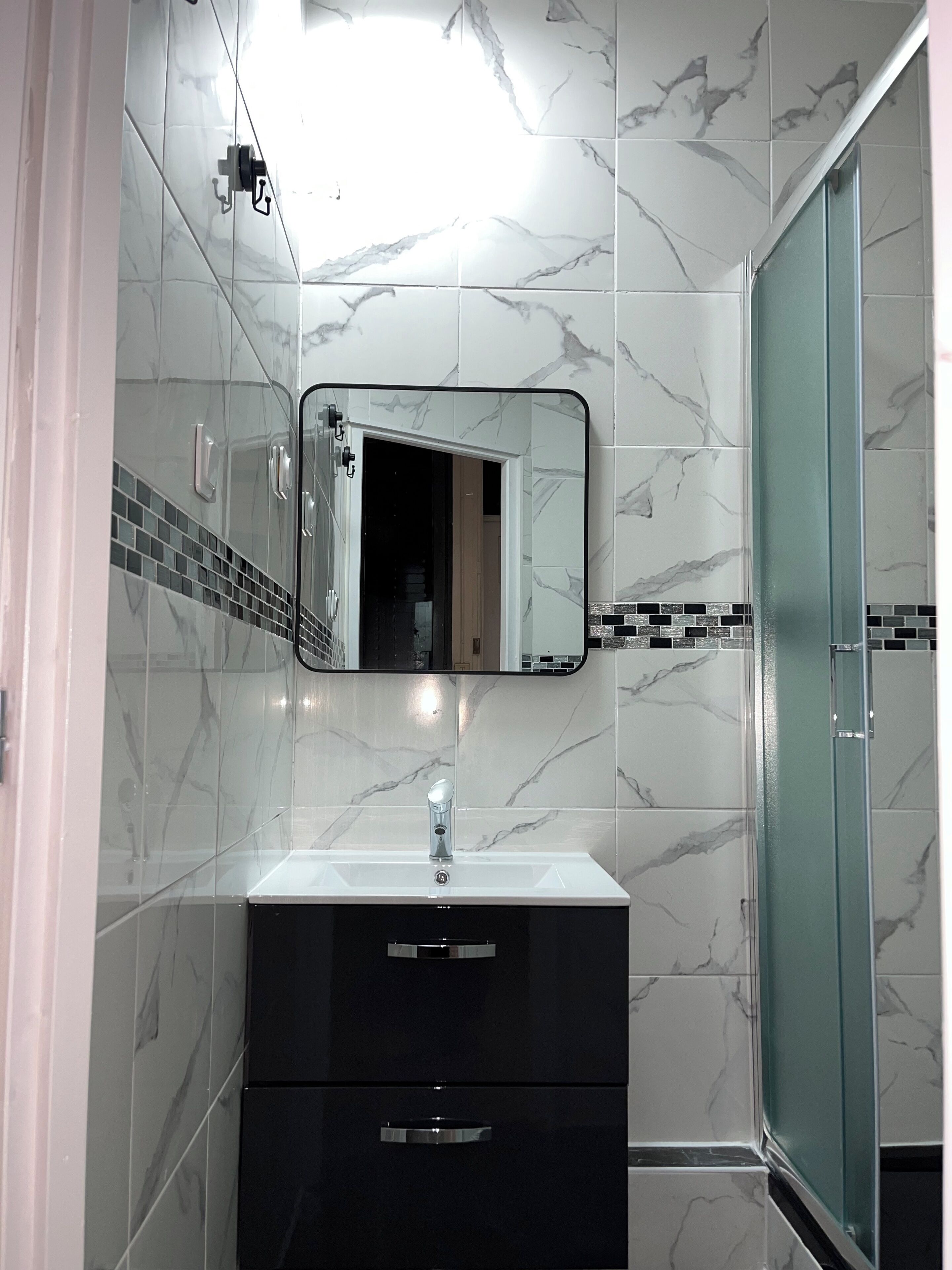 Een douche, handdoeken, zeep, toiletpapier