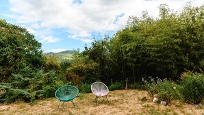 Un espace extérieur avec deux chaises et une vue sur un paysage boisé.