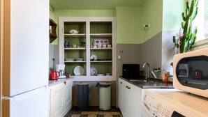 Une cuisine compacte équipée d’un lave-linge, d’un four à micro-ondes et d’un évier.