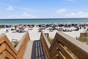 A beach with wooden walkways, umbrellas, and beach chairs. - Inviting 2 Bedroom Condo in Beachside II at Sandestin Golf and Beach Resort (Miramar Beach)