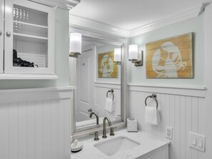 A bathroom with a white vanity, a large mirror, two wall-mounted lights, and a towel rack. - Inviting 2 Bedroom Condo in Beachside II at Sandestin Golf and Beach Resort (Miramar Beach)