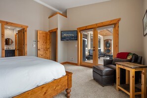 Une chambre à coucher avec un lit en bois, une petite table et un canapé.