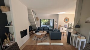 Un saló modern amb escala, zona de dinar decorada amb estels de mar, i vista a l'exterior.