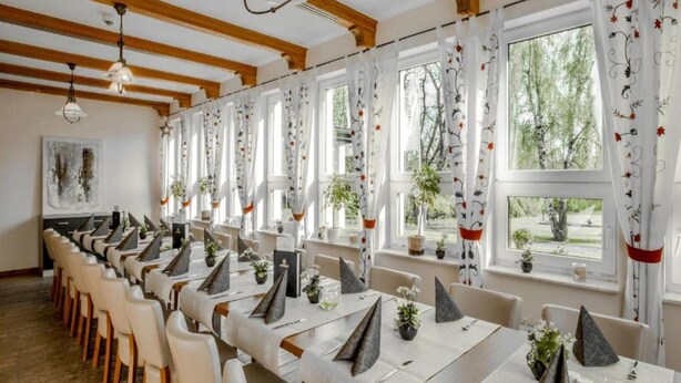 A dining area with long tables, white chairs, and decorative elements like plants and geometric centerpieces. - Kaiserhof Feldberg by Belvilla Resorts-twin Room (Feldberger Seenlandschaft)