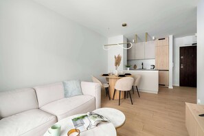 Ein modernes Wohnzimmer mit einer Couch, einem Couchtisch und einem Essbereich mit Tisch und Stühlen.