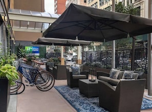 Ein Außenbereich mit Korbmöbeln, einem Fahrrad und einem Holiday Inn Express Schild im Hintergrund.