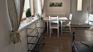 Una habitación con ventana, aire acondicionado, muebles blancos y una puerta con panel decorativo.