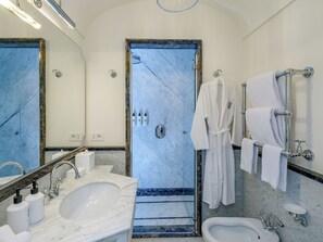 Un baño con lavamanos de mármol, un bidé, una bañera y una ducha.
