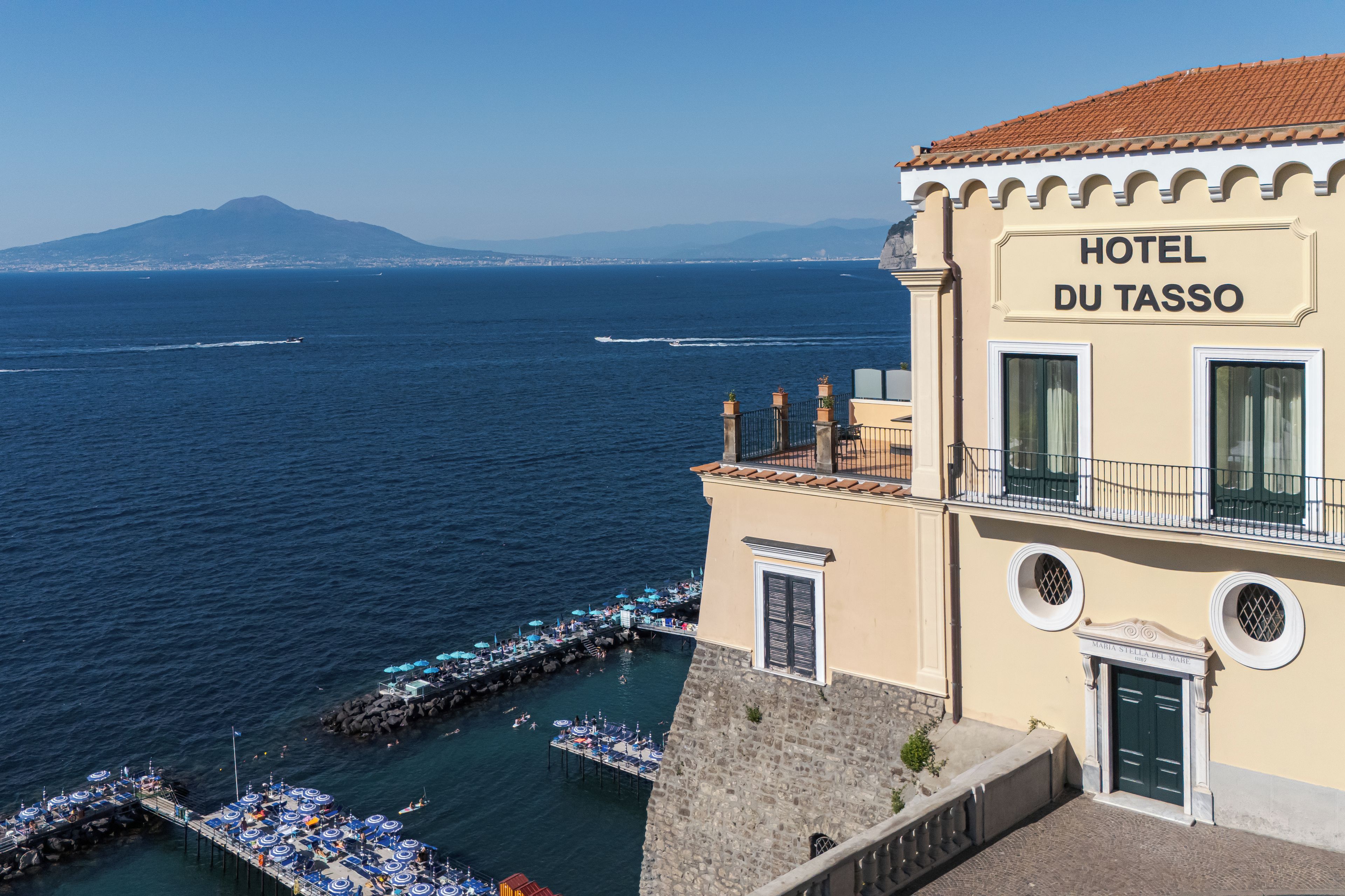 Ein Hotel an der Küste mit Blick auf das Meer und die dahinterliegenden Berge.