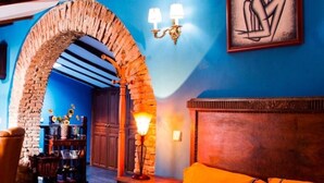 A room with a brick archway, a wooden headboard, and a blue wall. - Tictágora House: House 2 (Plasenzuela)
