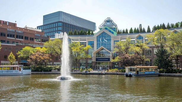 A fountain in a park with a building labeled "Cambridgeside" in the background.