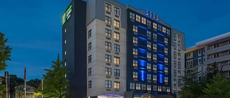 A modern hotel with a prominent sign for Hampton Inn Express. It features a multi-story structure with a mix of window types and a well-lit entrance.