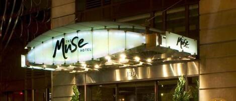 A hotel with a marquee sign reading "MUSE HOTEL" and a number "130" on the facade.