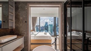 A modern hotel room with a city view, a large bathtub, and a spacious bed. - OPERA Premier Residence By An Gia Hospitality (Ho Chi Minh City)