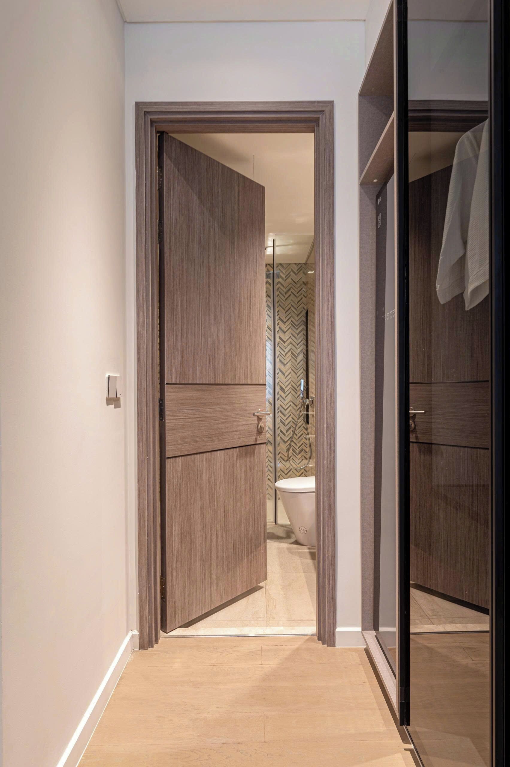 A modern bathroom with a toilet, shower, and a mirror.