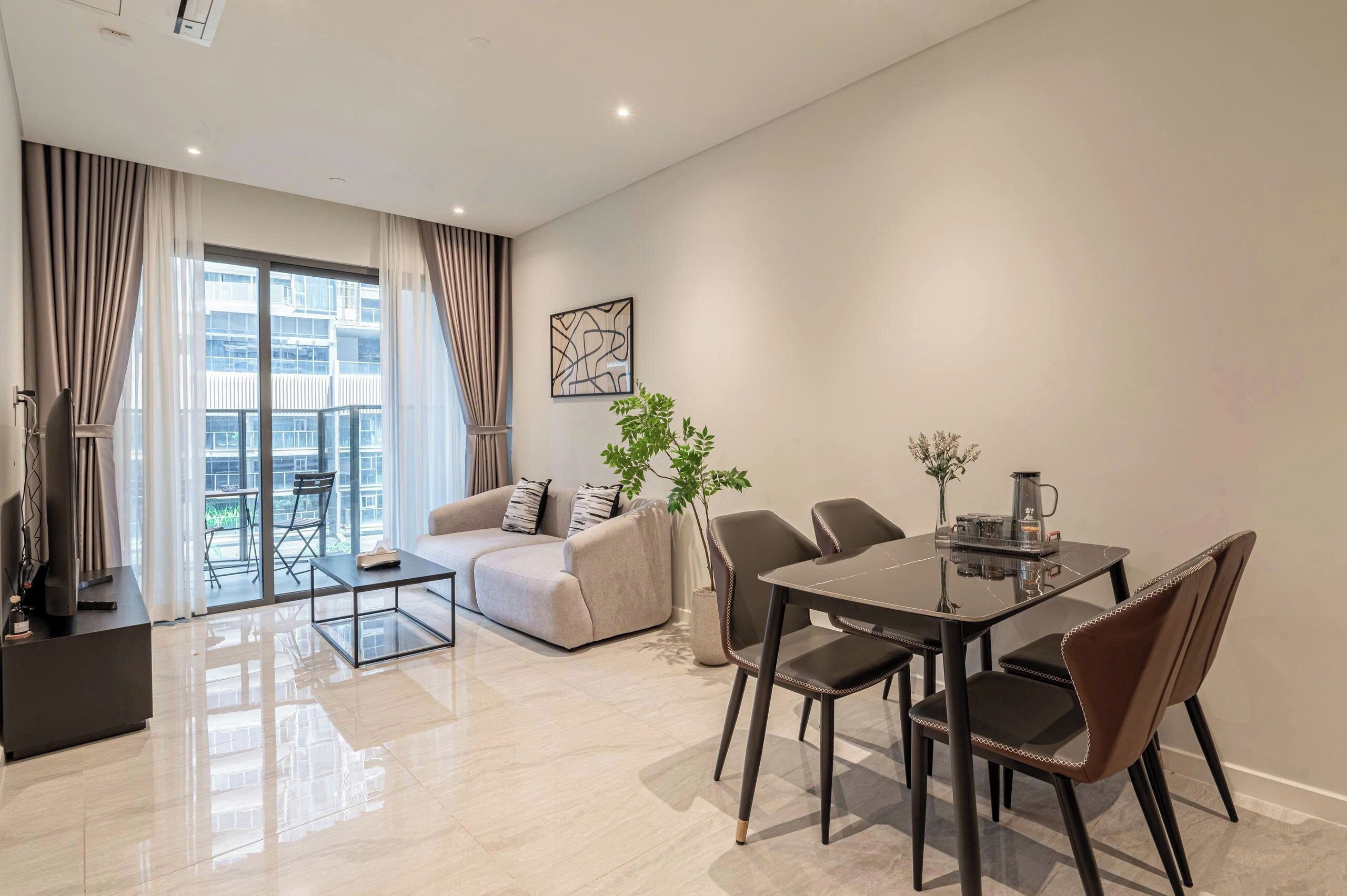 Un salon moderne comprenant un canapé, une table basse et une table à manger avec des chaises.