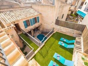 A rooftop pool area with multiple lounge chairs and a small pool. - Town house in Alagaida (Algaida)