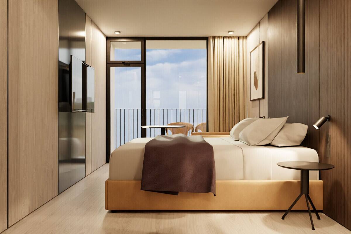 A modern hotel room with a large bed, a small table, a chair, and a balcony with a city view.
