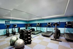 A gym with treadmills, elliptical machines, and free weights. - Steps to High Line + On-Site Cocktail Lounge (New York)
