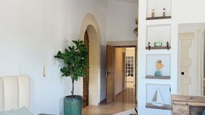 Ein Schlafzimmer mit einem großen Bett, einer Topfpflanze und einem Holzbalken an der Decke.