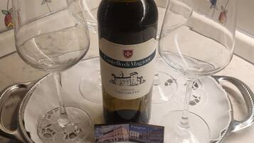 Una bottiglia di vino Grechetto dell'Umbria, Castello di Magione, con due bicchieri vuoti su un vassoio.