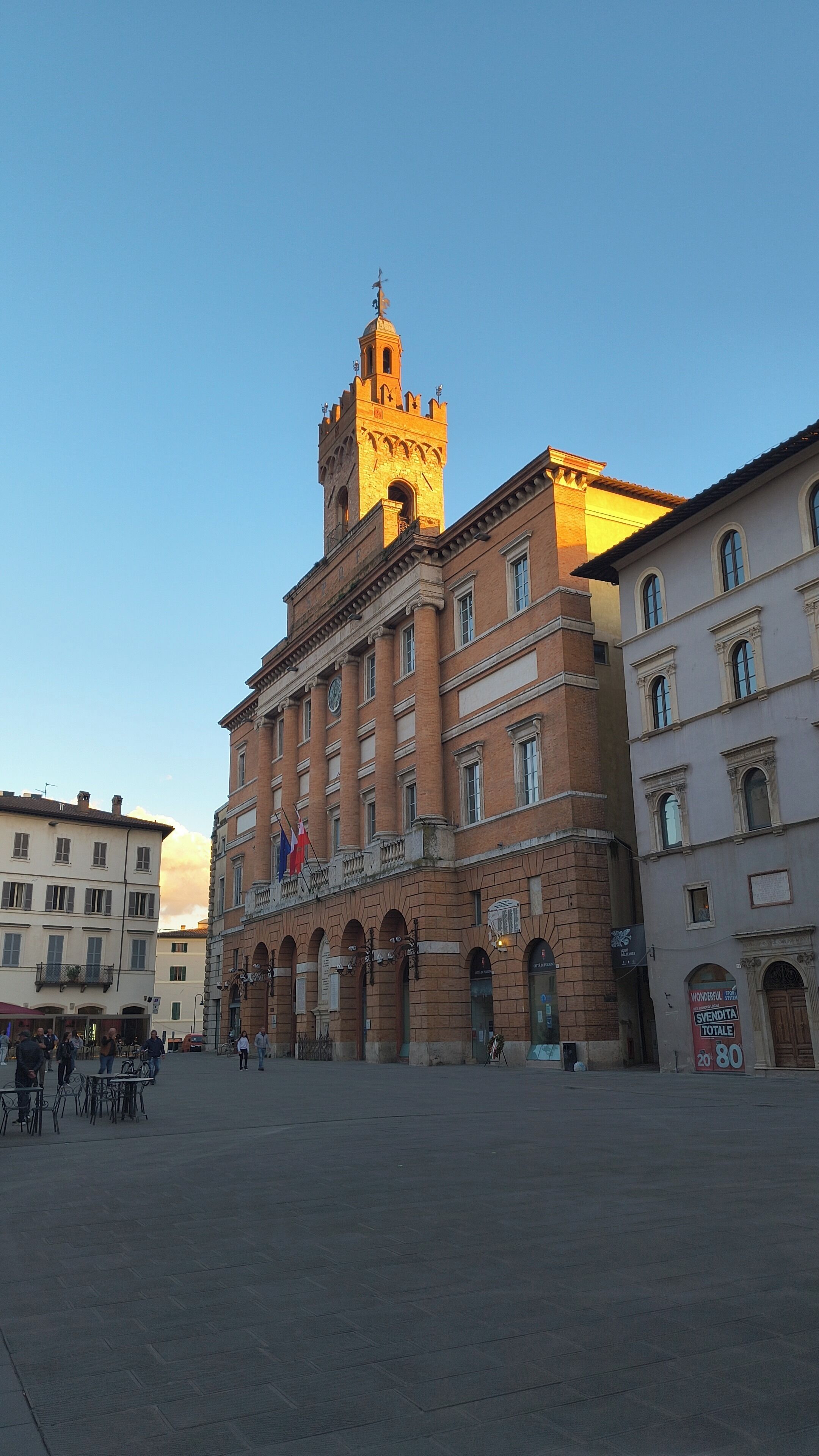A historic building with a prominent tower, arched windows, and a central courtyard.