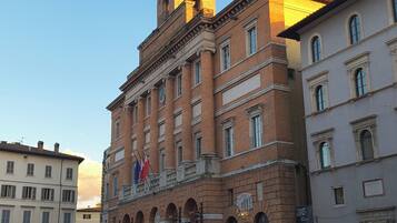 A historic building with a prominent tower, arched windows, and a central courtyard.