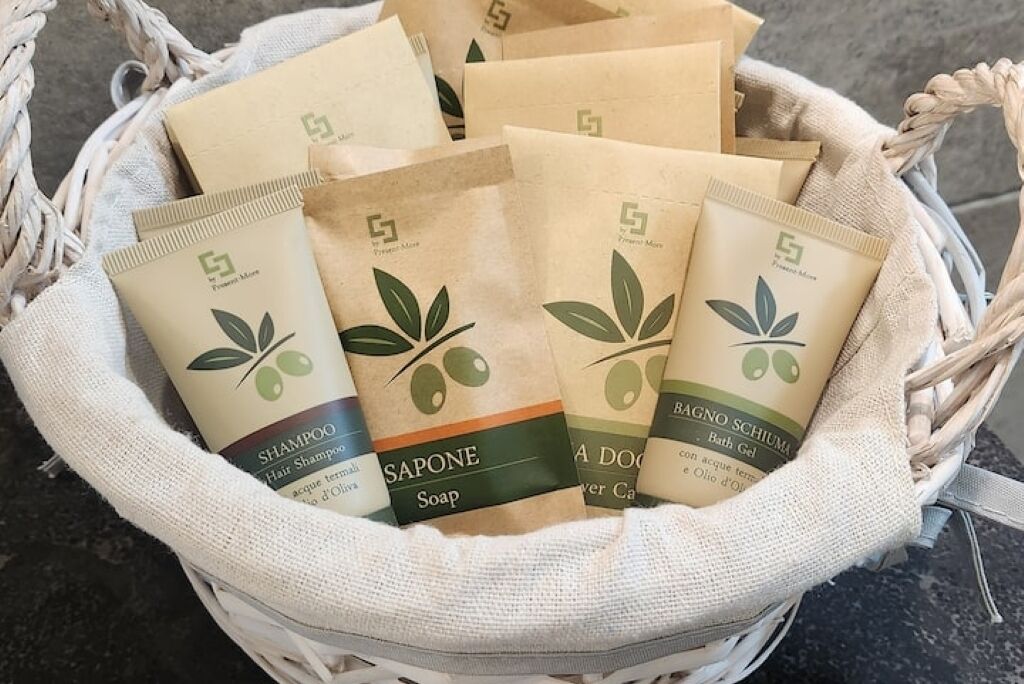 Un panier contenant plusieurs produits emballés, portant un logo et une mention indiquant qu’il s’agit de produits naturels ou biologiques, comme du shampoing, du savon et du gel douche.