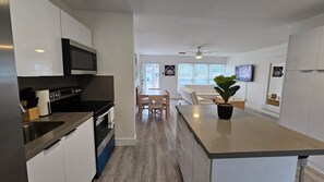 A modern kitchen with a central island, a dining area with a table and chairs, and a ceiling fan. - F. Lauderdale Near Casino & Beach 3 Bedroom House (Fort Lauderdale)