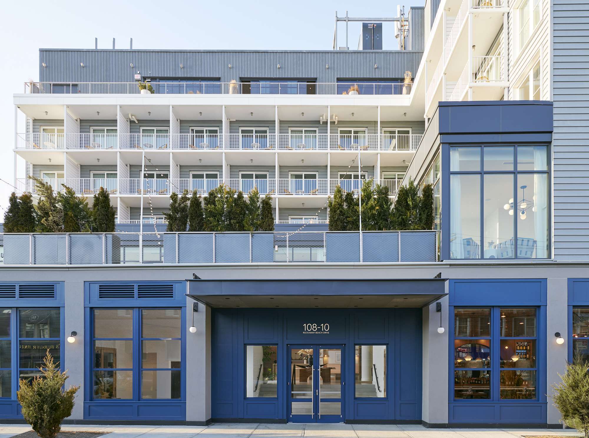 A multi-story hotel with balconies, large windows, and a ground-level entrance.