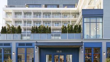 A multi-story hotel with balconies, large windows, and a ground-level entrance.