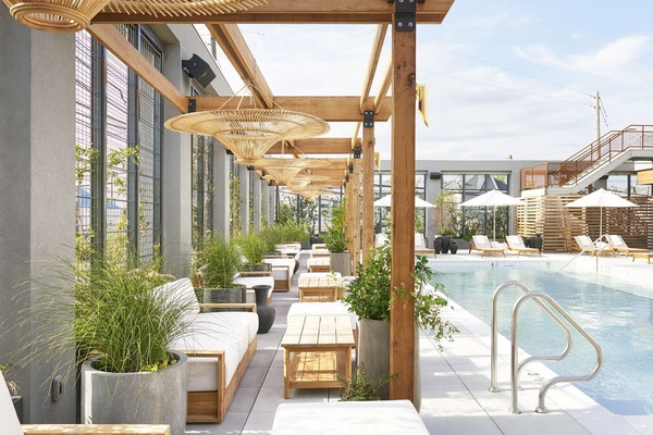 Long pool view with loungers, umbrellas, and wood structures