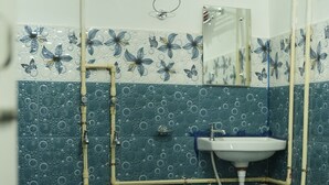 A bathroom with a shower, sink, and toilet. - Shivalik stays  (East Jorhat)
