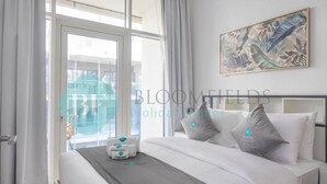Une chambre d’hôtel avec un lit, une fenêtre avec des rideaux et une œuvre d’art accrochée au mur.