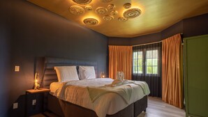 A bedroom with a bed, nightstands, a green wardrobe, and a ceiling with circular light fixtures. - The Private Garden The Ambassador (Jan Thiel)