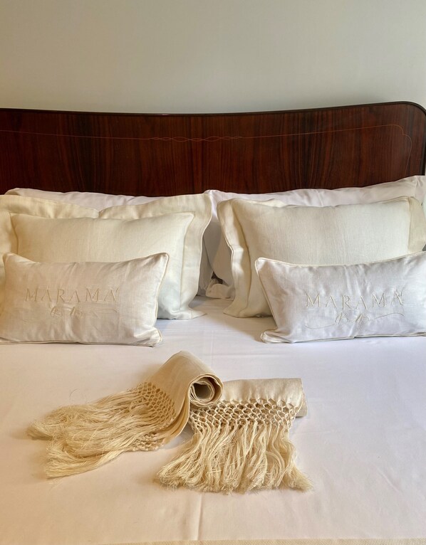 A neatly made bed with white linens and two pillows with embroidered text. - Maramà B&B Sorrento (Sorrento)