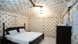 Un dormitorio con cama, ventilador de techo y armario.