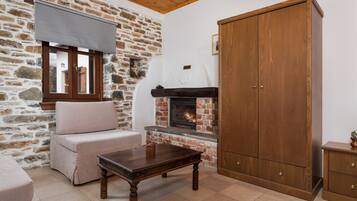 Ein gemütlicher Raum mit Steinwand, Holzschrank, Kamin und gepolstertem Sitz.