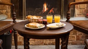 Un coin petit-déjeuner accueillant, avec une table, des chaises et une cheminée.