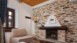 Une pièce chaleureuse avec une cheminée en pierre, un canapé et une table basse en bois.