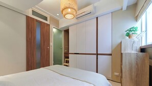 Ein Schlafzimmer mit einem Bett, einem Kleiderschrank und einer Pendelleuchte.