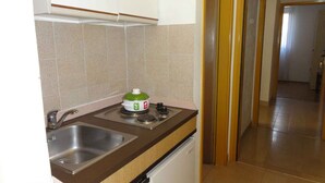 Una cuina compacta amb un doble safareig, un never petit i una cuina.