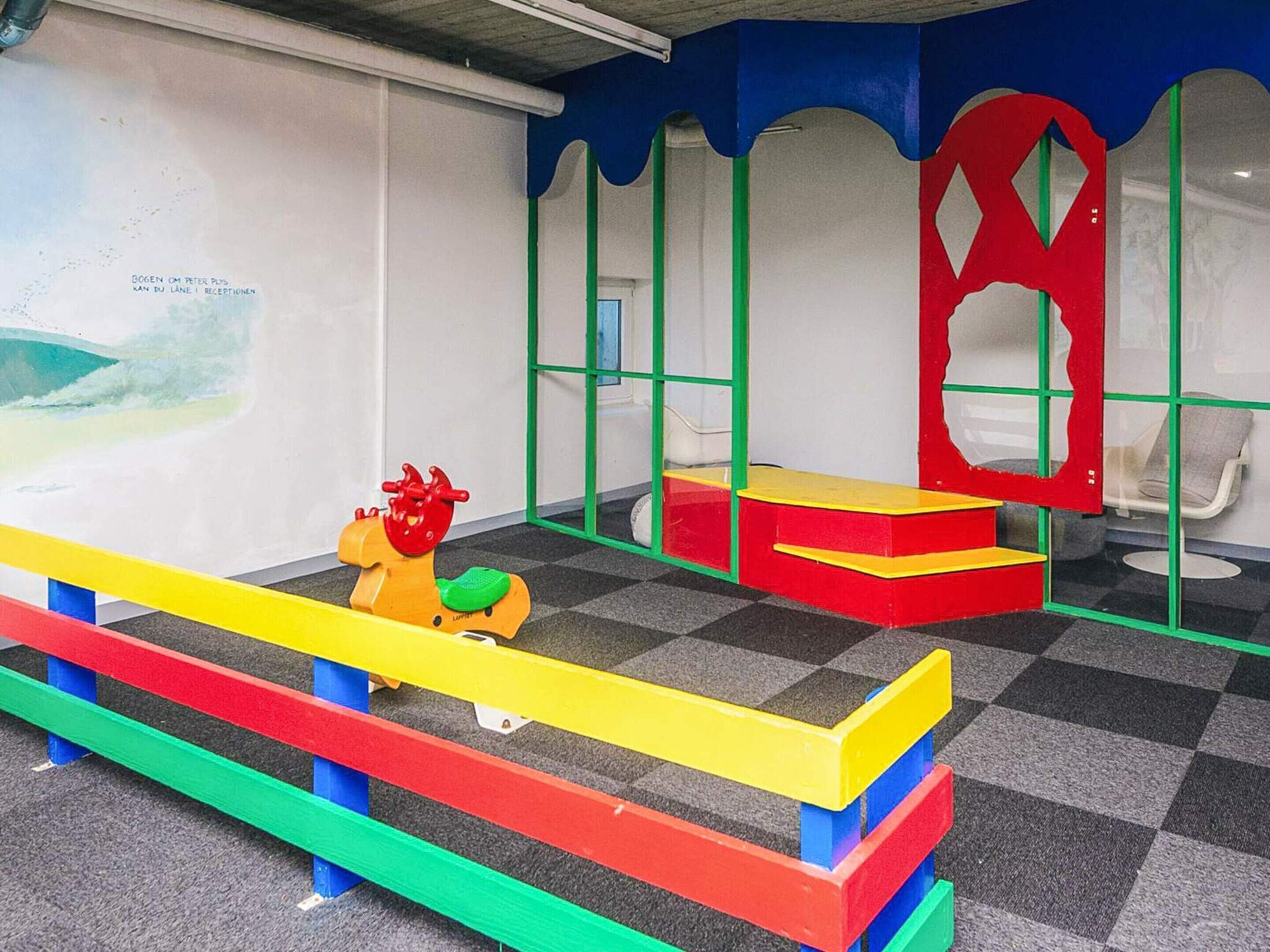 A children's play area with colorful equipment and a checkered floor.